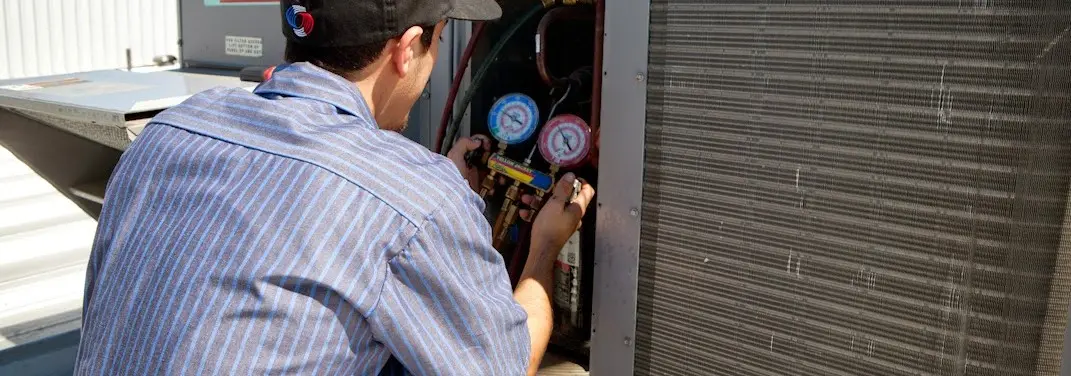 HVAC technician servicing a condenser unit in Azle